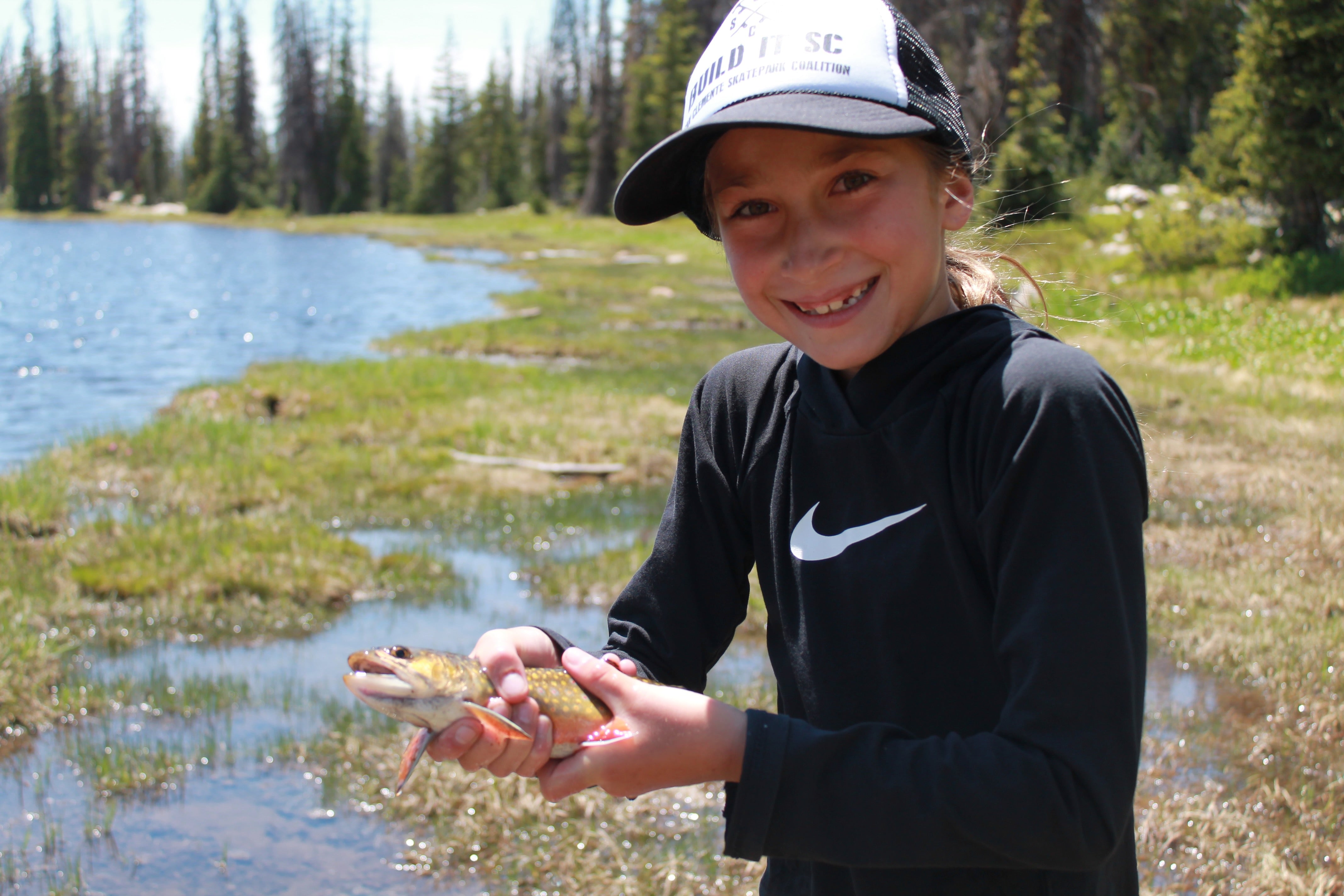 A kid fly fishing a mountain stream for the first time