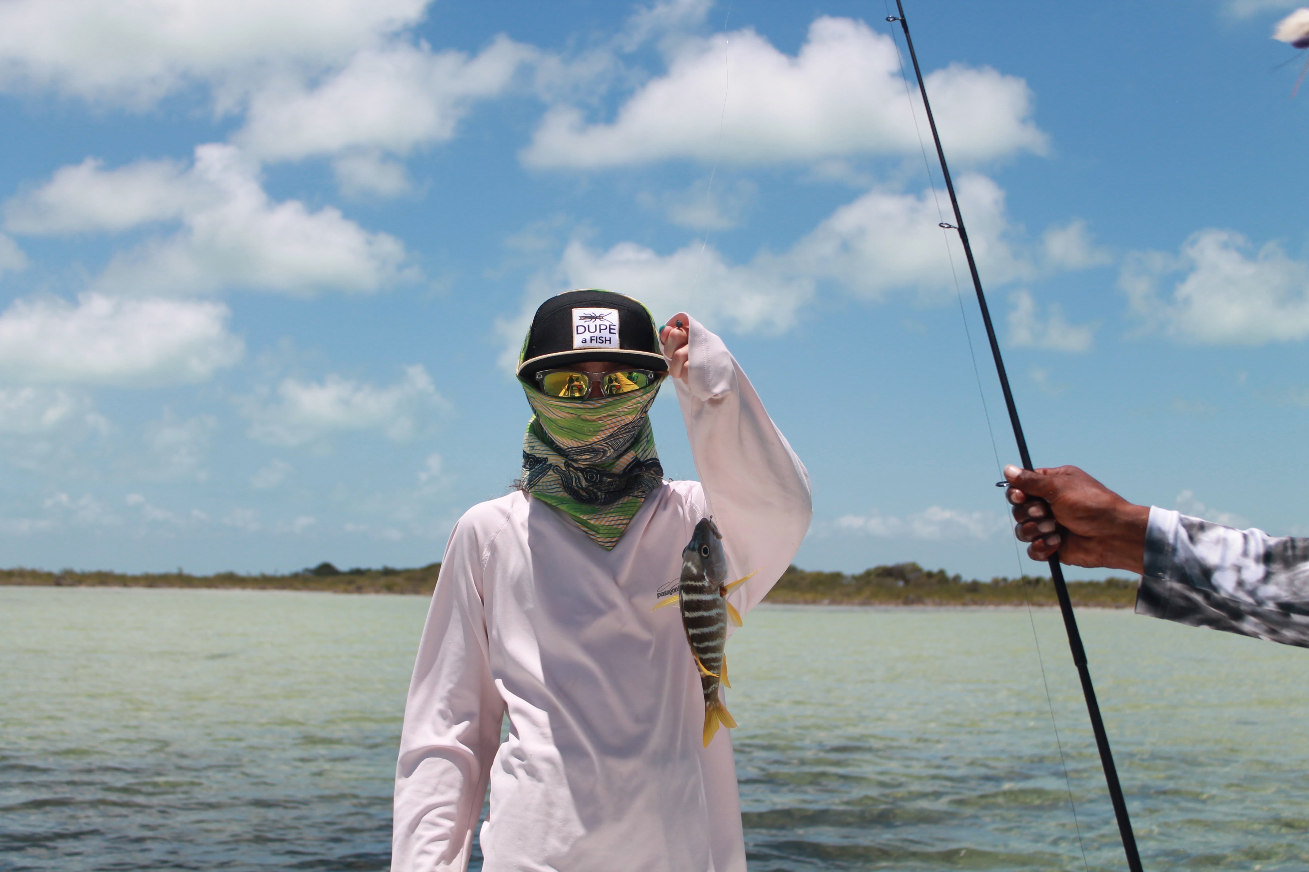 A kid fishing in Belize covered up against sun and elements