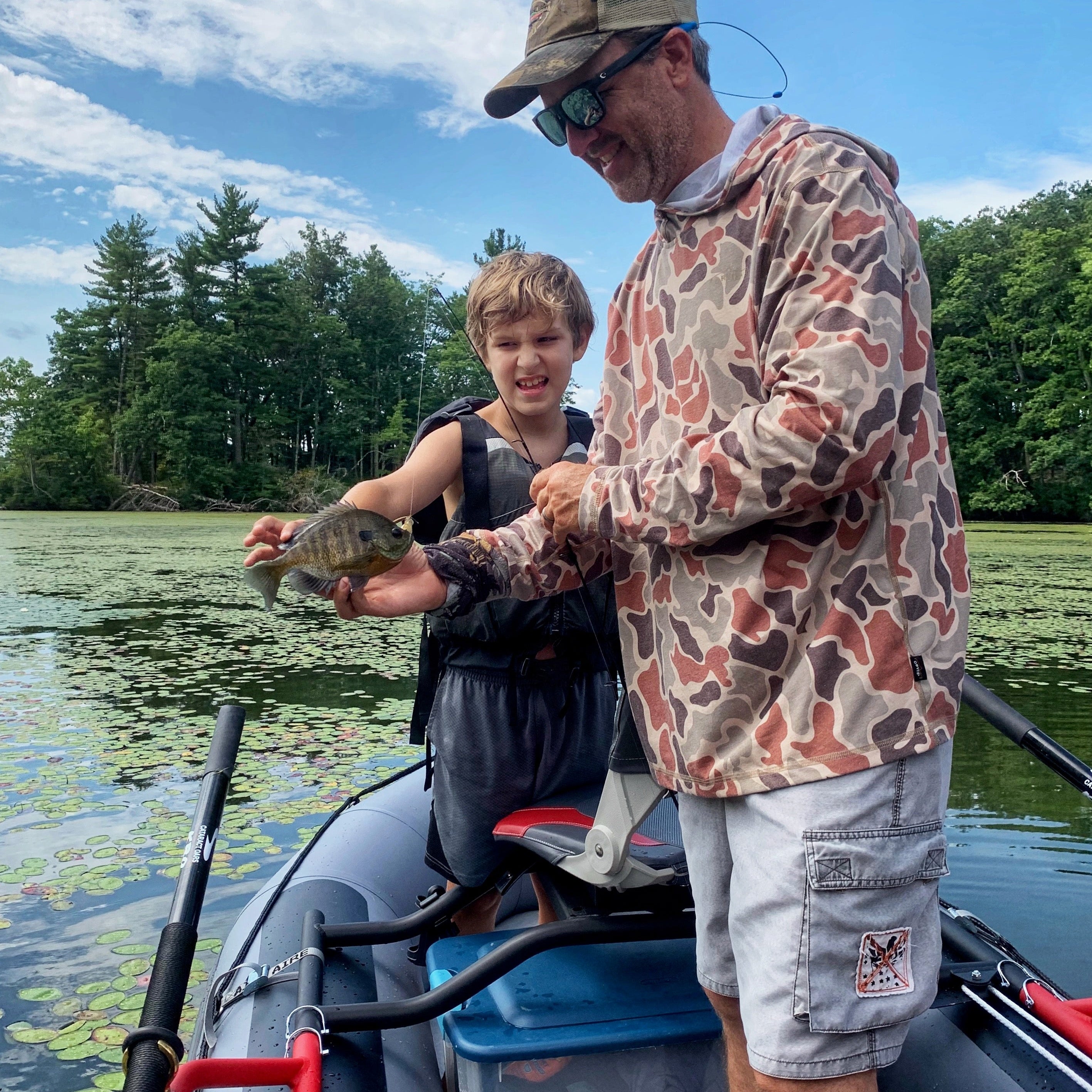 A kid fly fishing for bass with dad