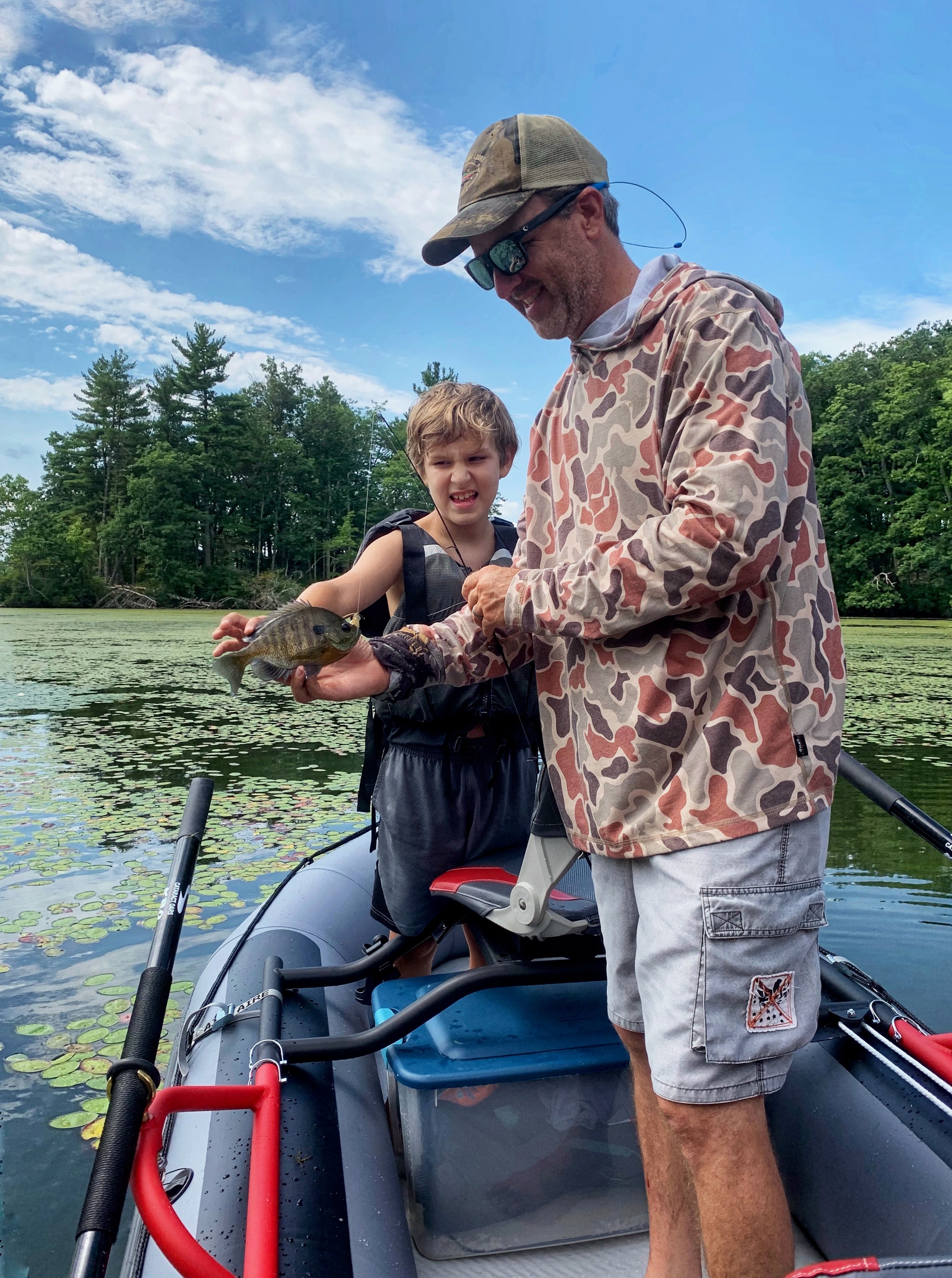 A kid fly fishing for bass with dad
