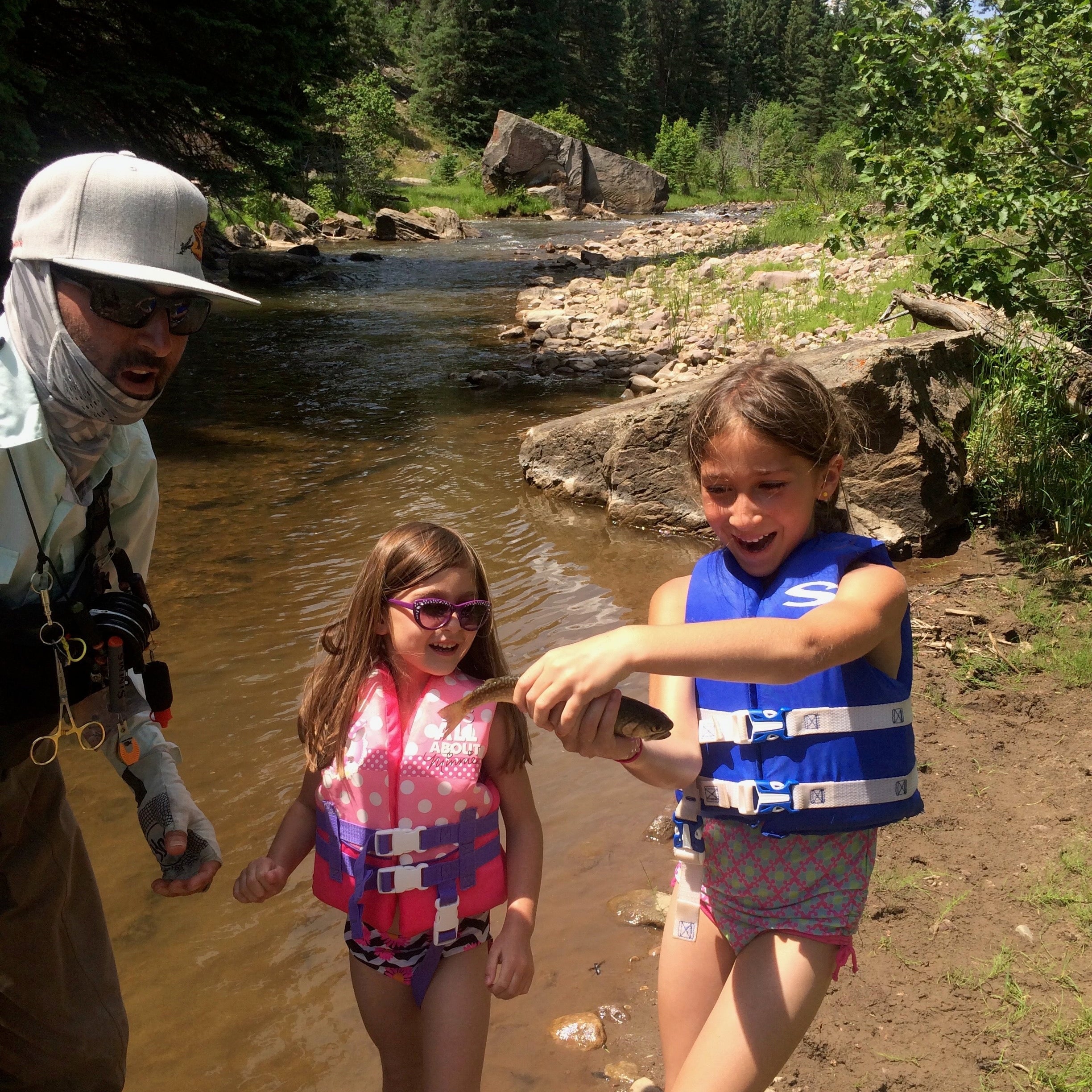 Two siblings fly fishing together on a river