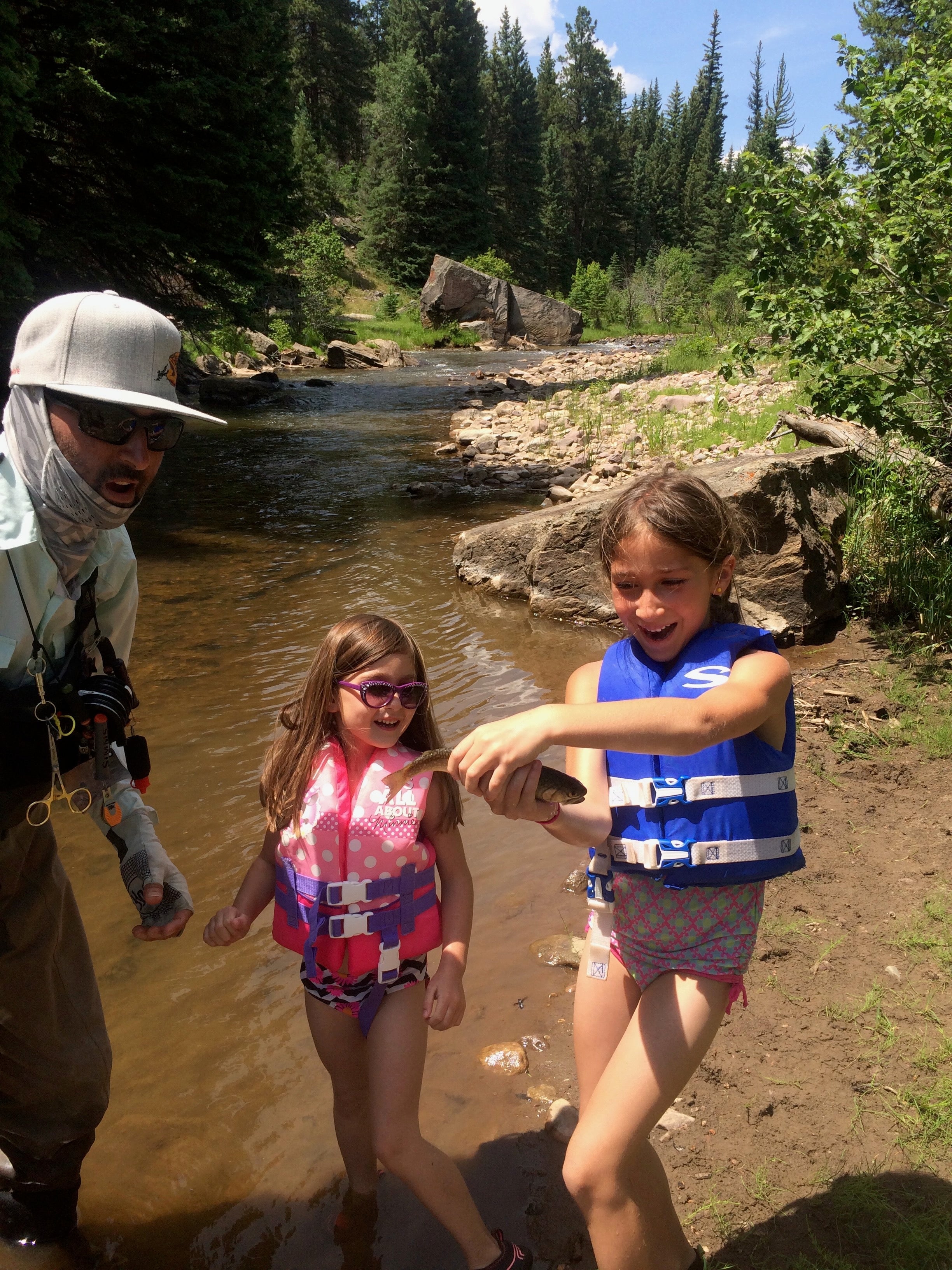 Two siblings fly fishing together on a river
