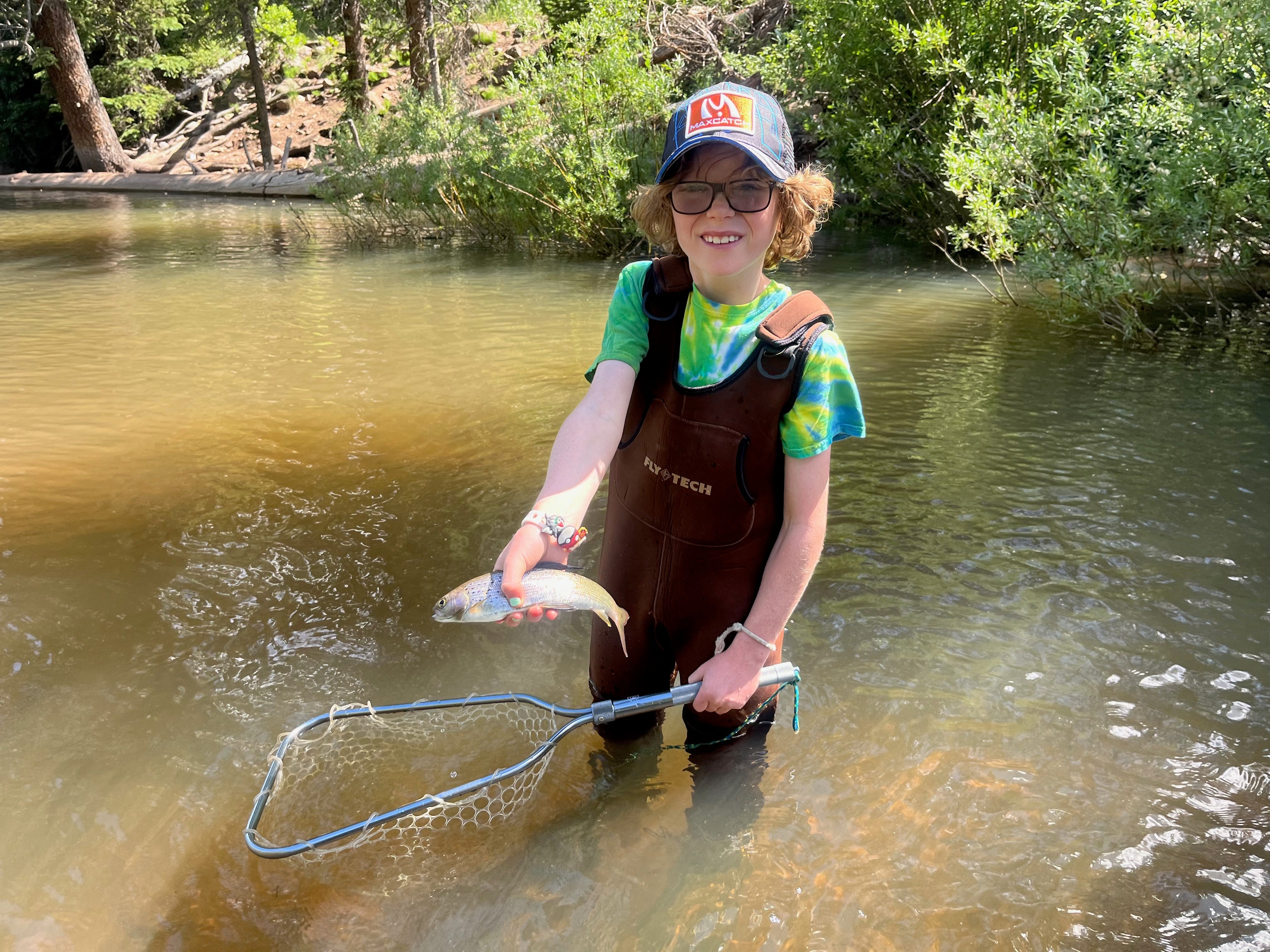 A young angler fly fishing independently along a river