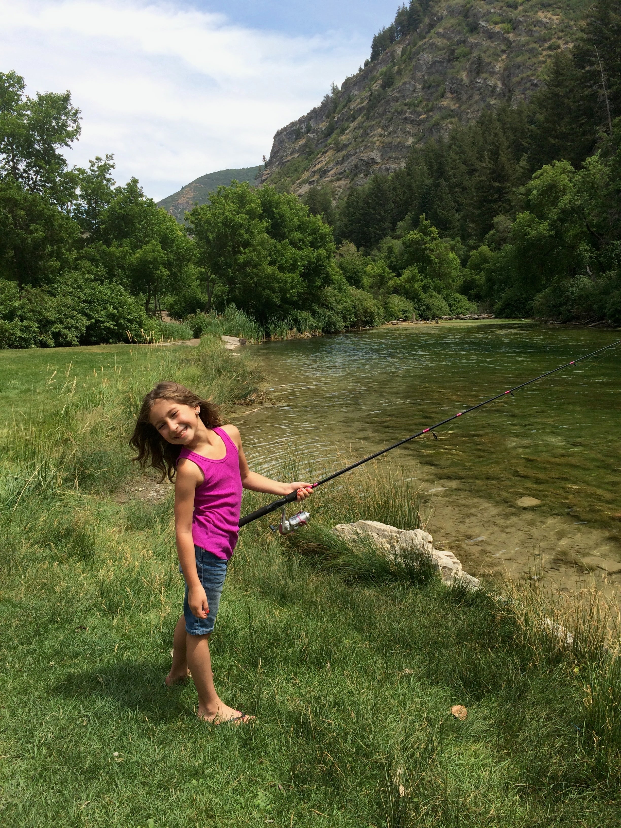 A kid spin fishing from the bank