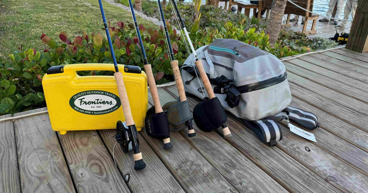 Fly rods, reels and a Frontiers travel case staged on a lodge dock before a flats trip