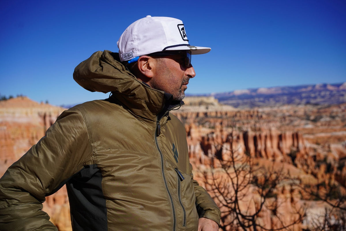 Olive Black Diamond synthetic insulated hoody with black stretch side panels against a red-rock canyon backdrop