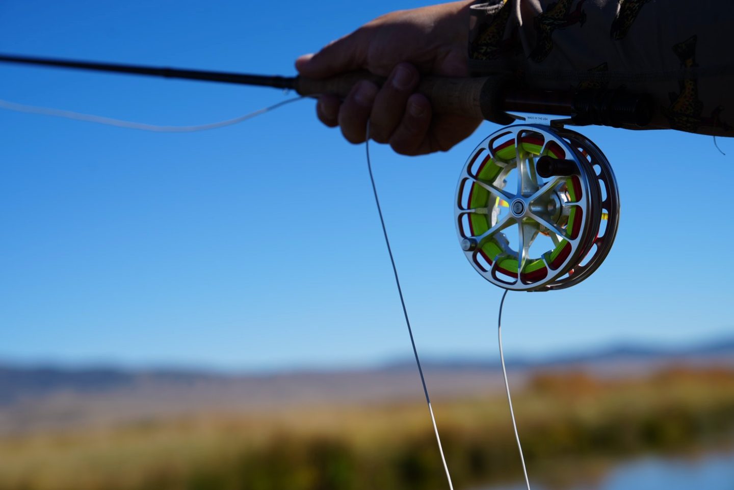 Fly reel and fly line against a blue sky
