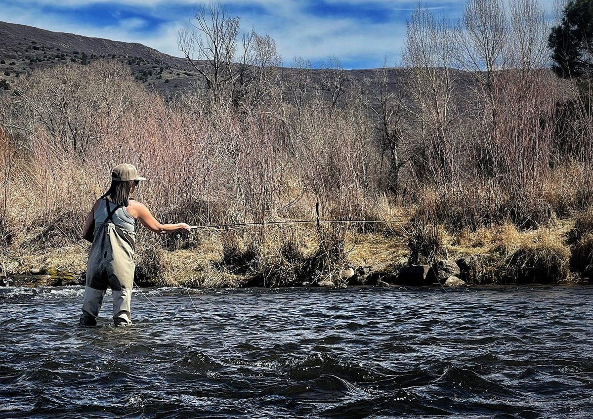 Angler wading a riffle and reading the water on a western river