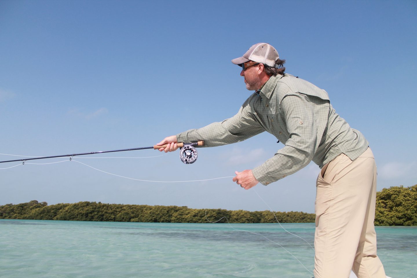 Angler casting from the bow of a skiff on a saltwater flat