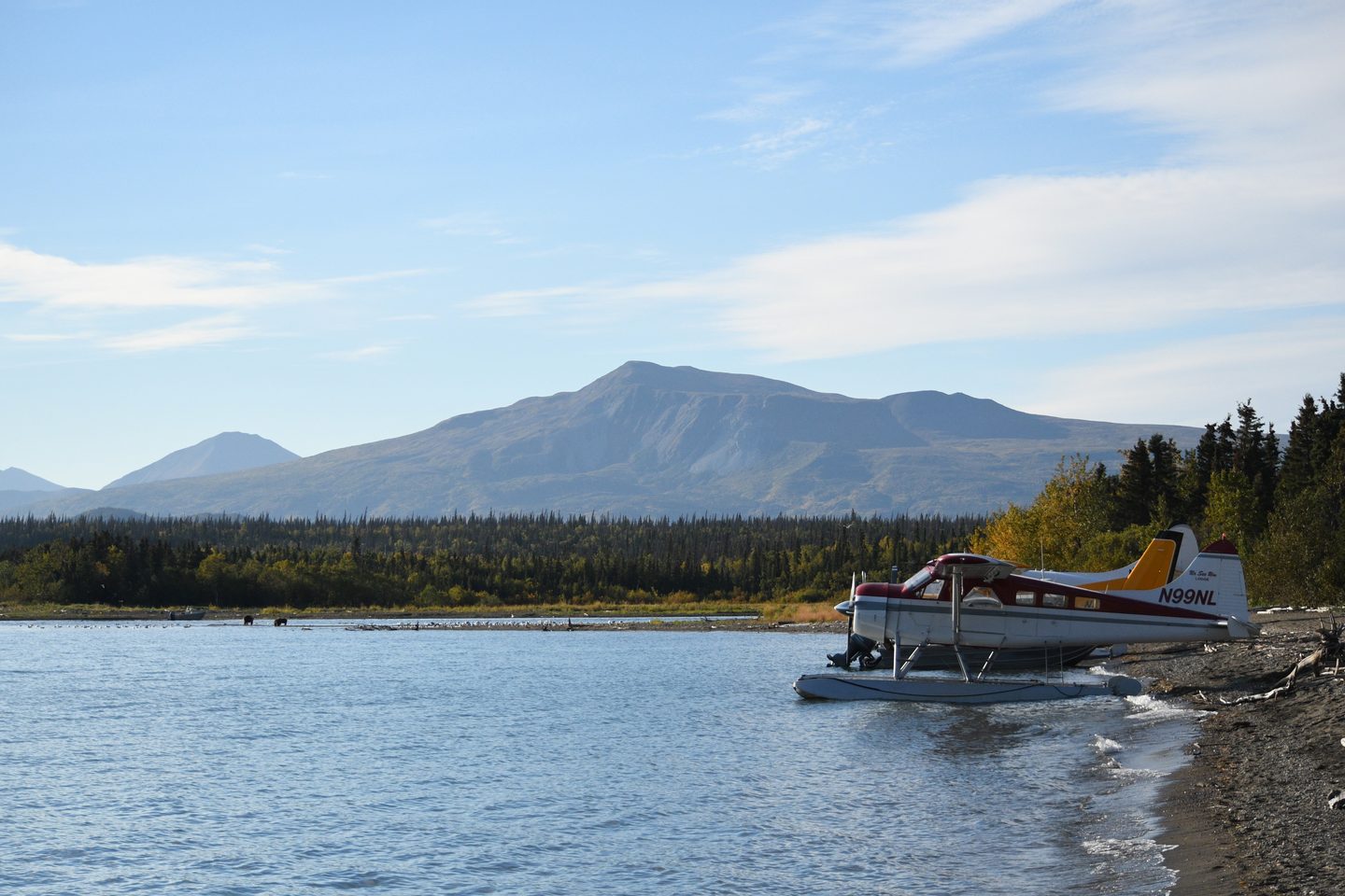 Floatplane parked on a lakeshore below a mountain on a fly fishing trip