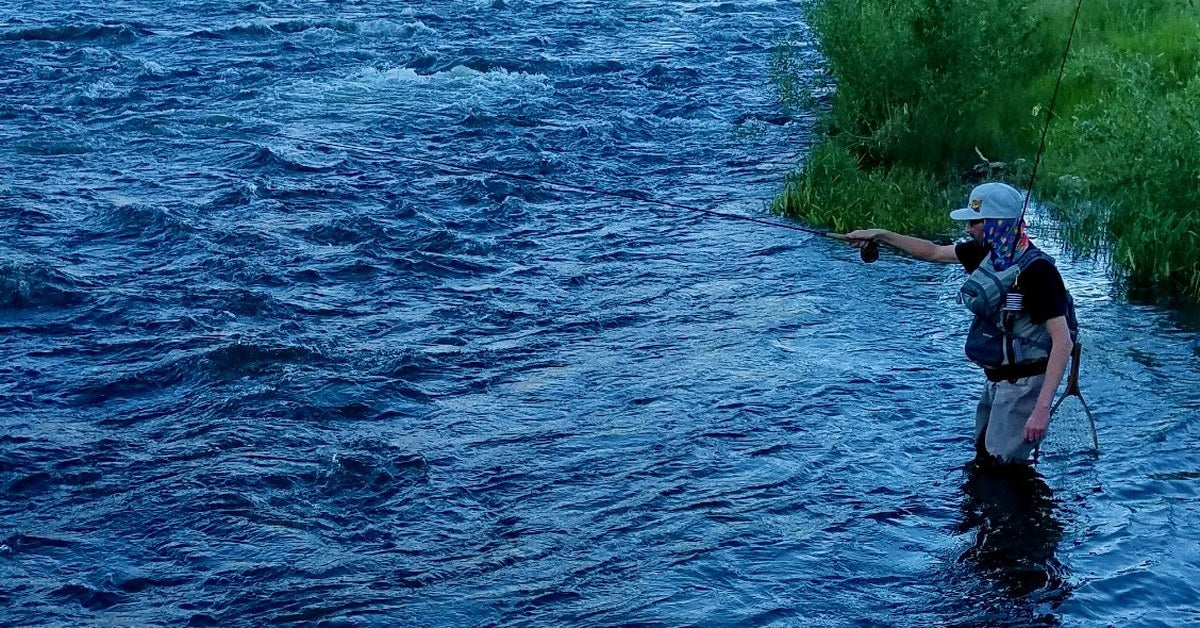 Angler tight-line nymphing a Utah river at dusk, rod extended across the current on a micro-leader mono rig
