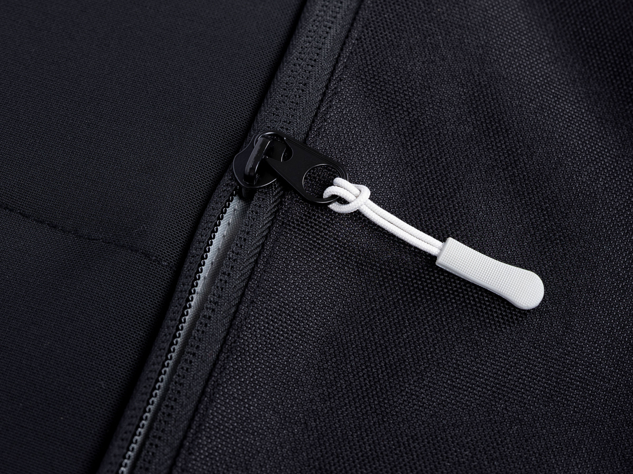 Black Ford Transit storage panel zipper with white pull tab and metal slider