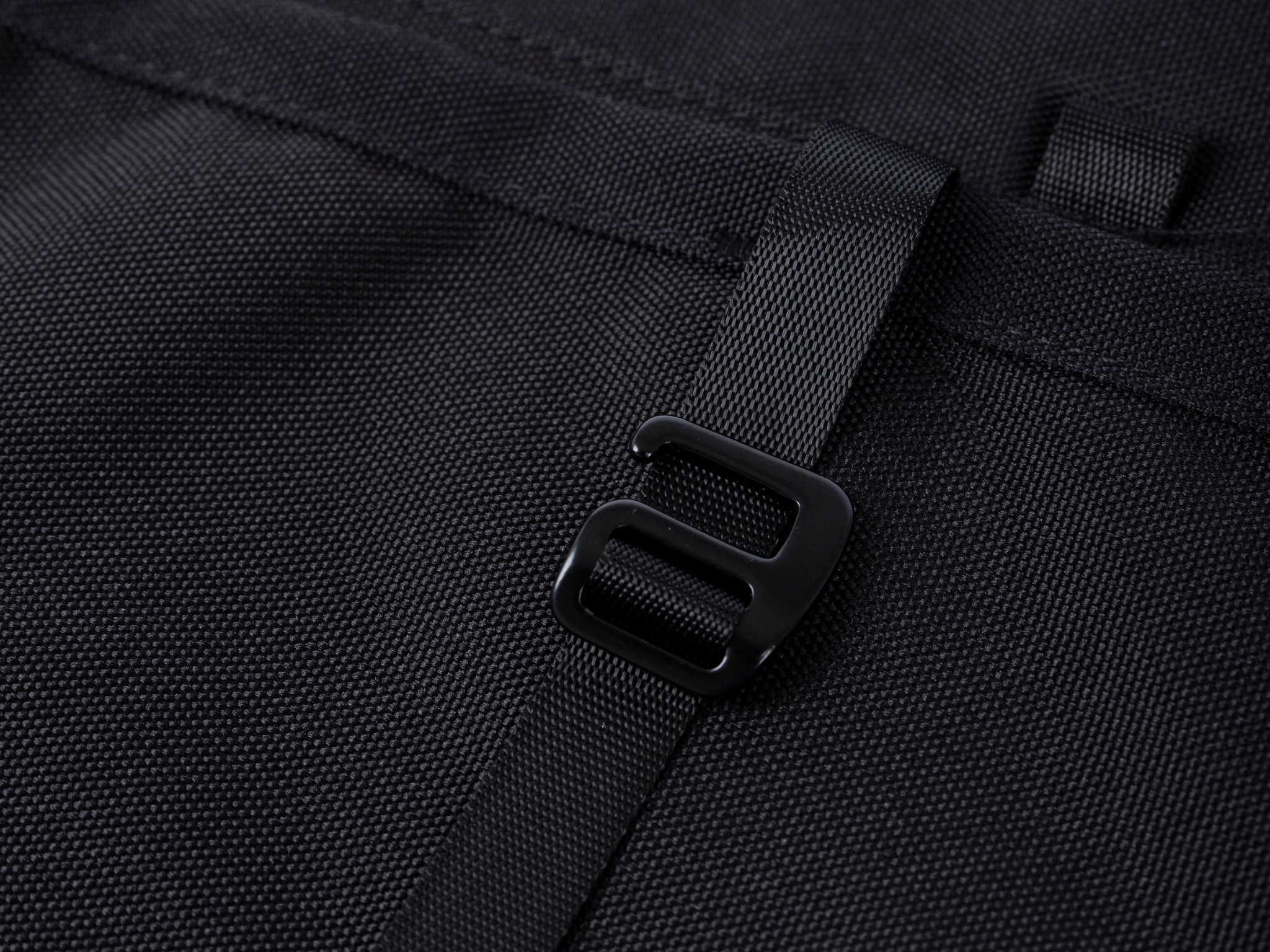 Black storage panel strap buckle/connector detail on textured fabric