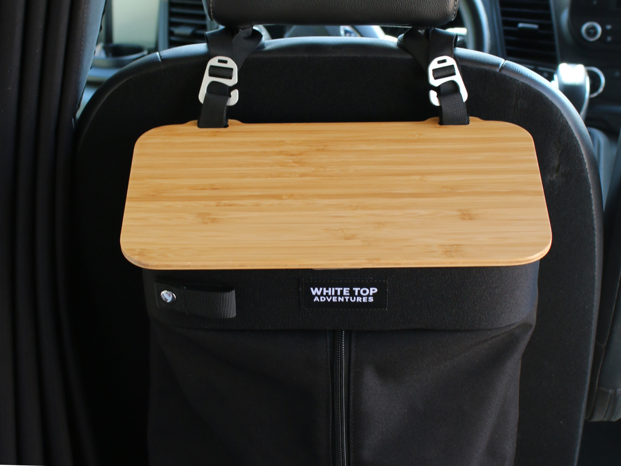 Black hanging trash bag with light wood top panel and mounting straps on seat