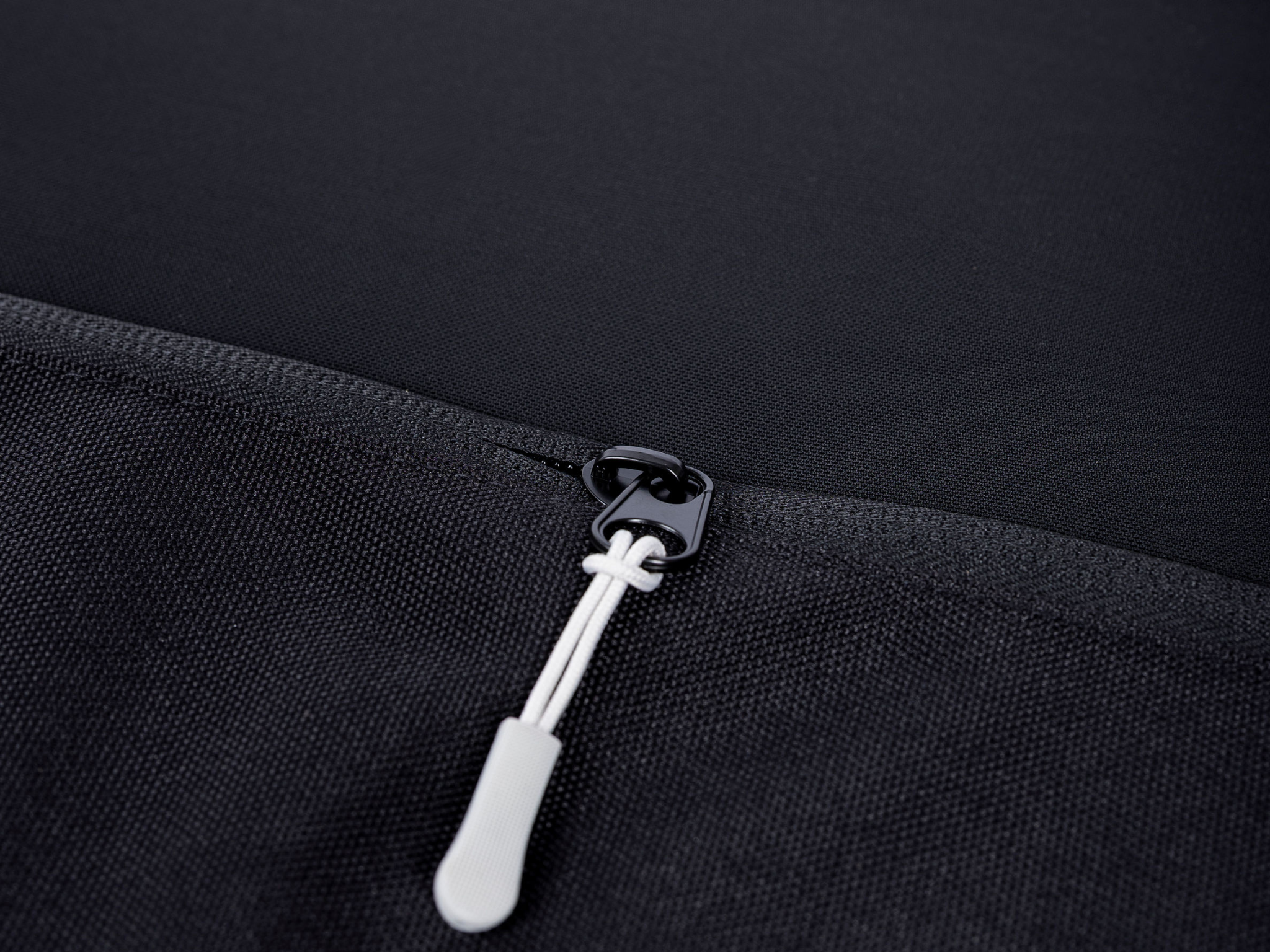 Black storage panel zipper with white pull and loop puller
