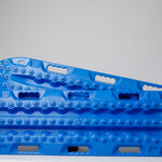 Pair of off-road traction recovery boards in blue, side profile with textured tread.