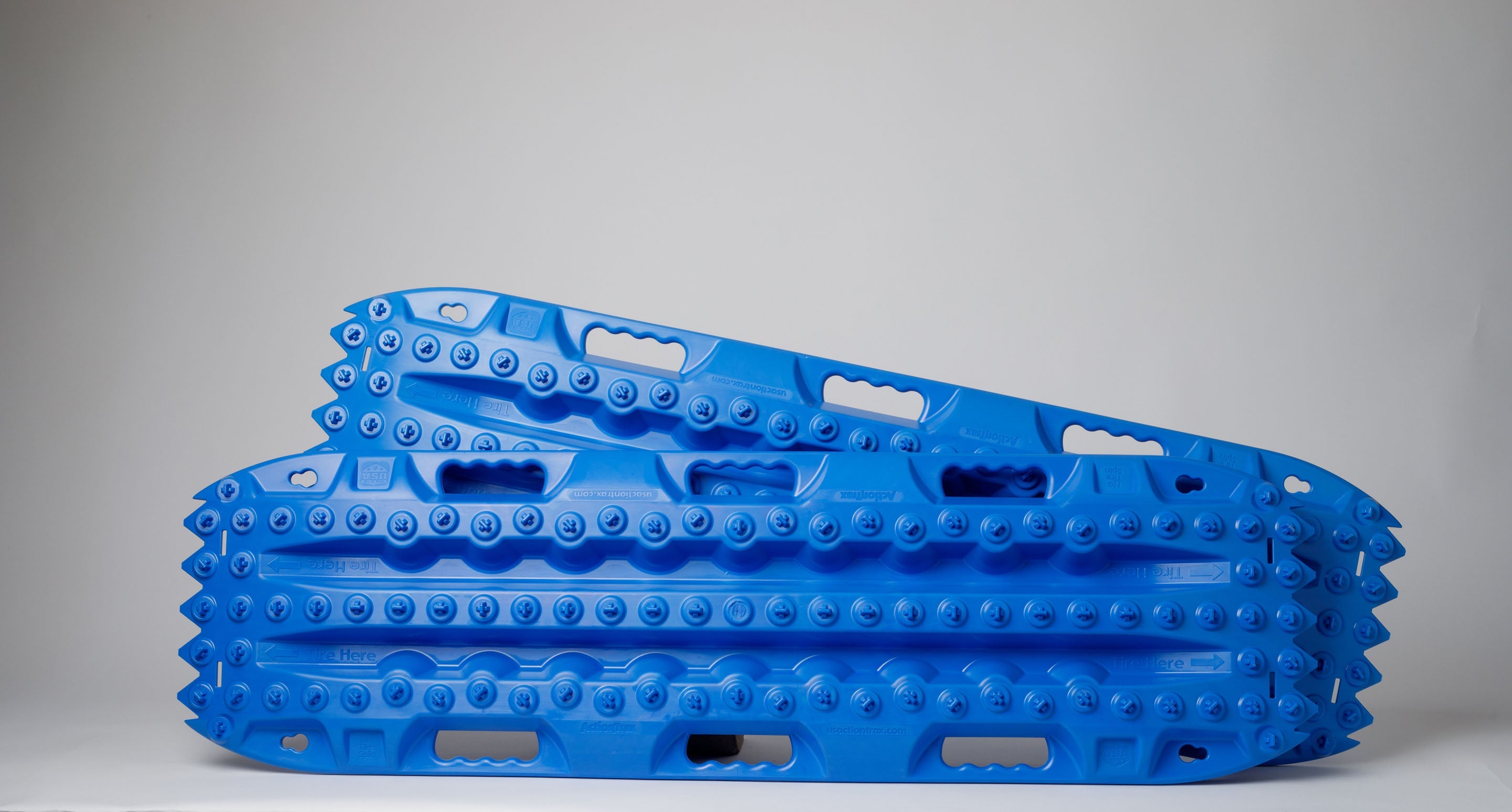 Pair of off-road traction recovery boards in blue, side profile with textured tread.
