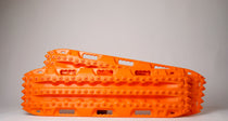 Orange off-road recovery traction boards pair with raised cleats