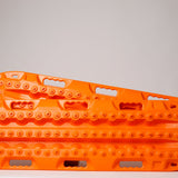 Orange off-road recovery traction boards pair with raised cleats