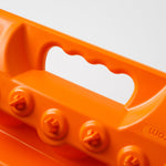 Orange traction recovery board underside with grip handle cutouts