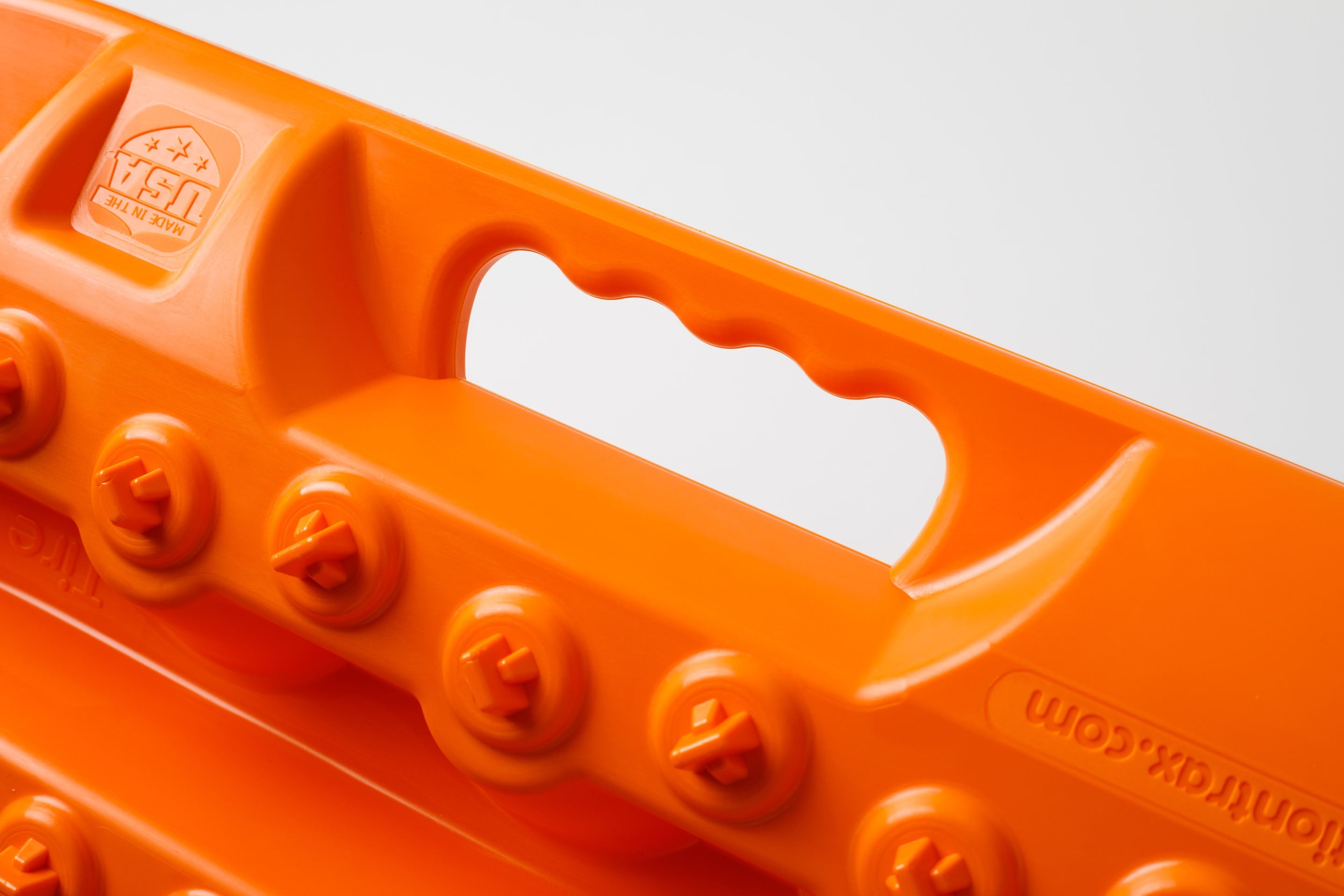 Orange traction recovery board underside with grip handle cutouts