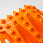 Orange traction recovery board tread with circular grip studs