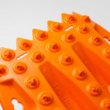 Orange traction recovery board tread with circular grip studs