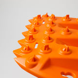 Orange traction board close-up showing cone-style studs