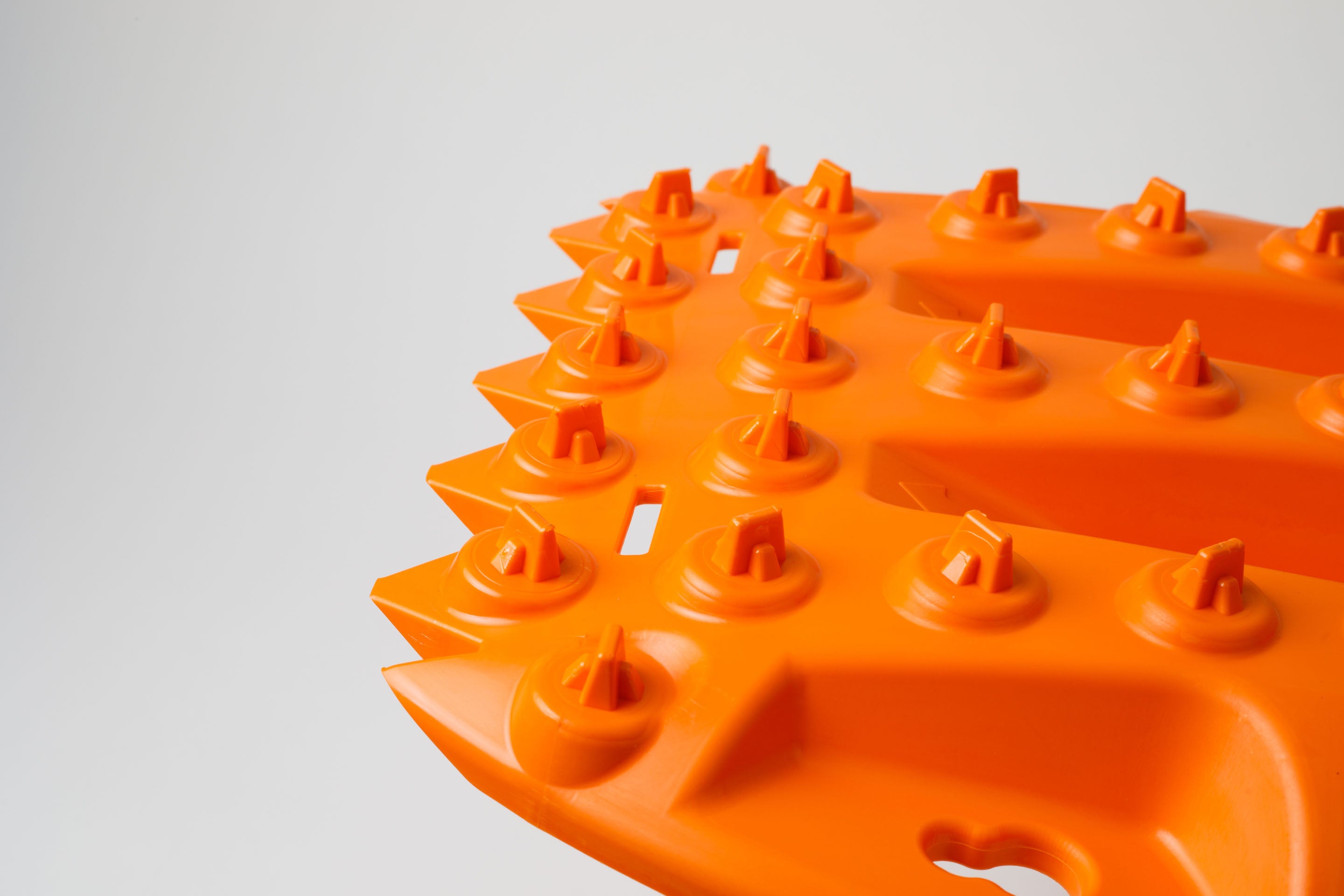 Orange traction board close-up showing cone-style studs