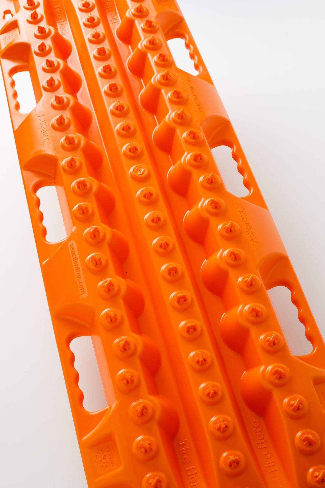 Orange traction recovery board with long grooves and molded tread buttons