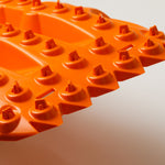 Orange traction mat close-up of raised round studs across tread