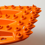Orange traction recovery board with deep traction lugs and dot-pattern studs