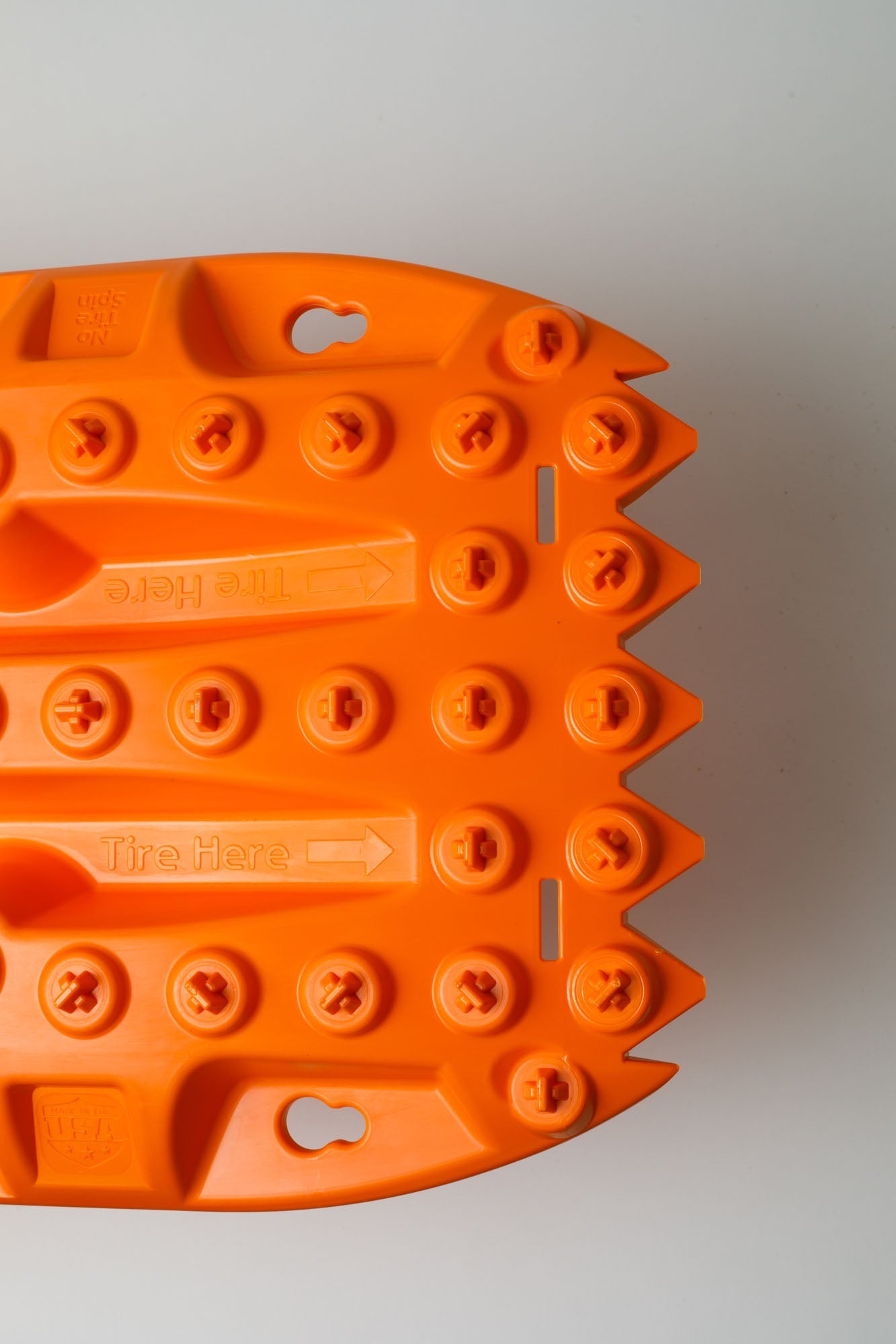 Orange traction mat tread end with toe slot and circular grip studs
