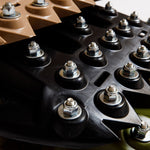 Black recovery traction mat with metal tooth studs and bolt heads