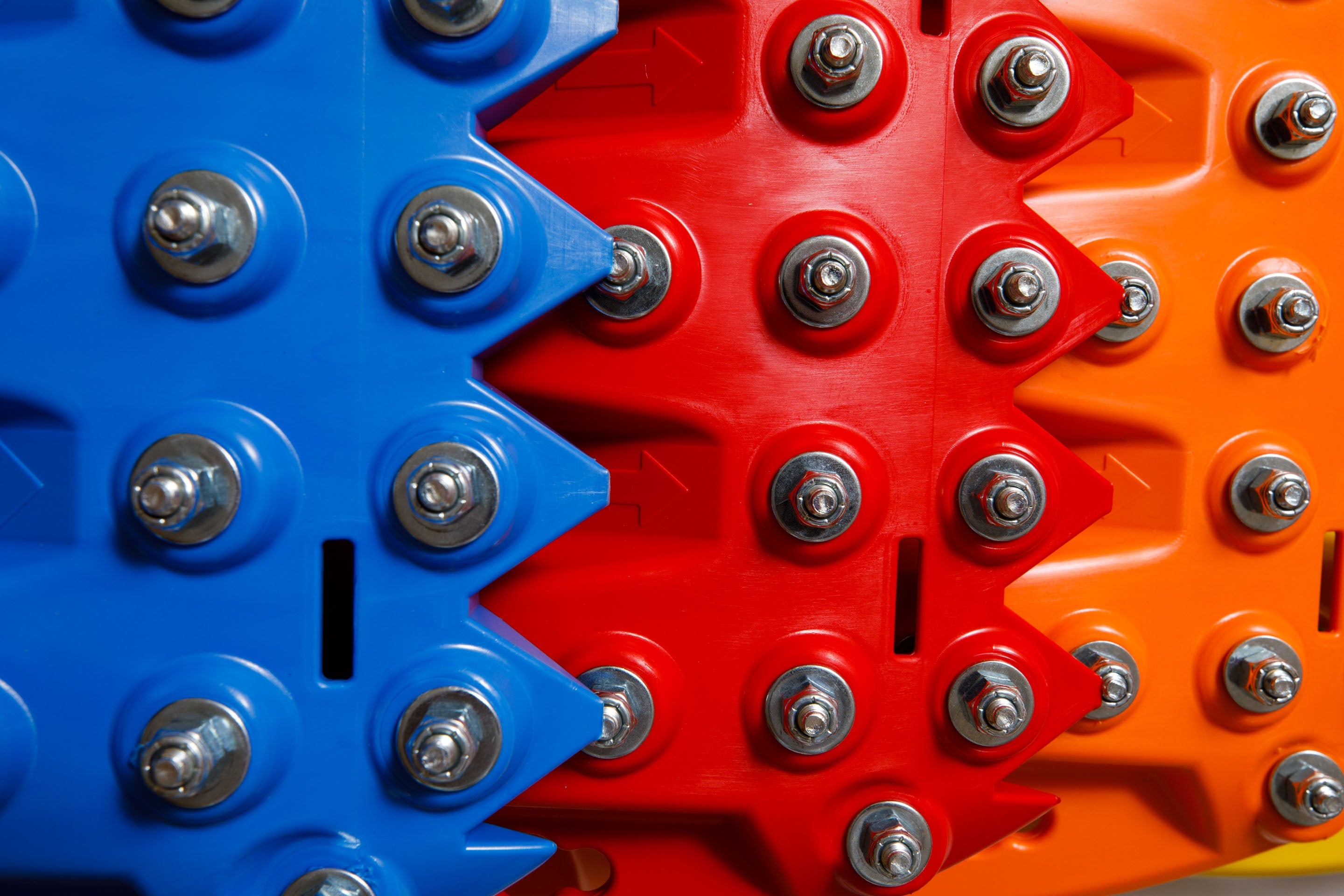 Close-up of blue and orange traction teeth with steel bolts