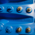 Close-up of blue traction mat with metal bolts on grip surface