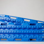 Blue recovery traction board with metal teeth along the edges