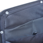 Dark blue storage panel corner with metal snaps and stitched pocket panel