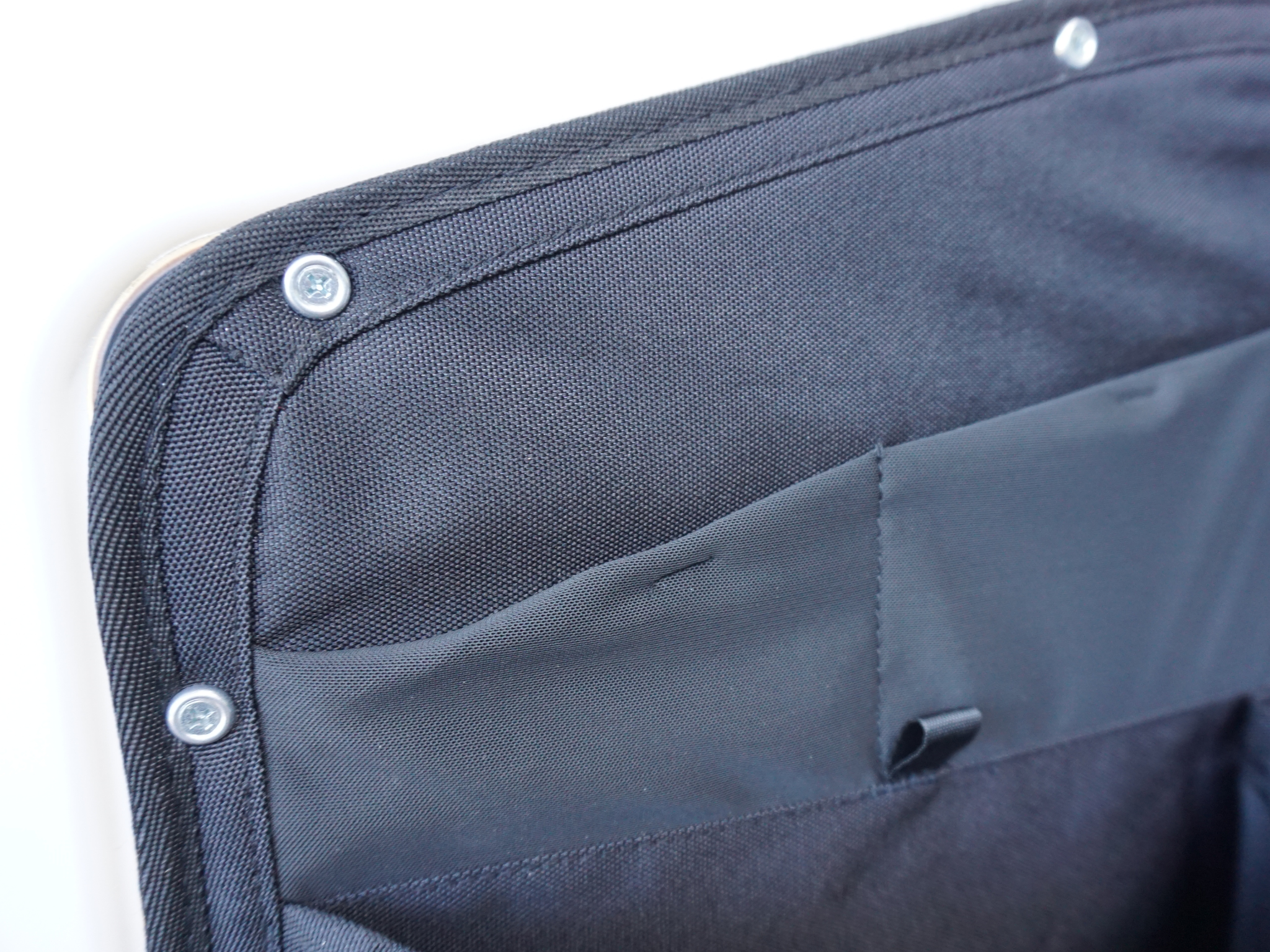 Dark blue storage panel corner with metal snaps and stitched pocket panel