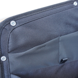 Dark blue storage panel corner with metal snaps and stitched pocket panel