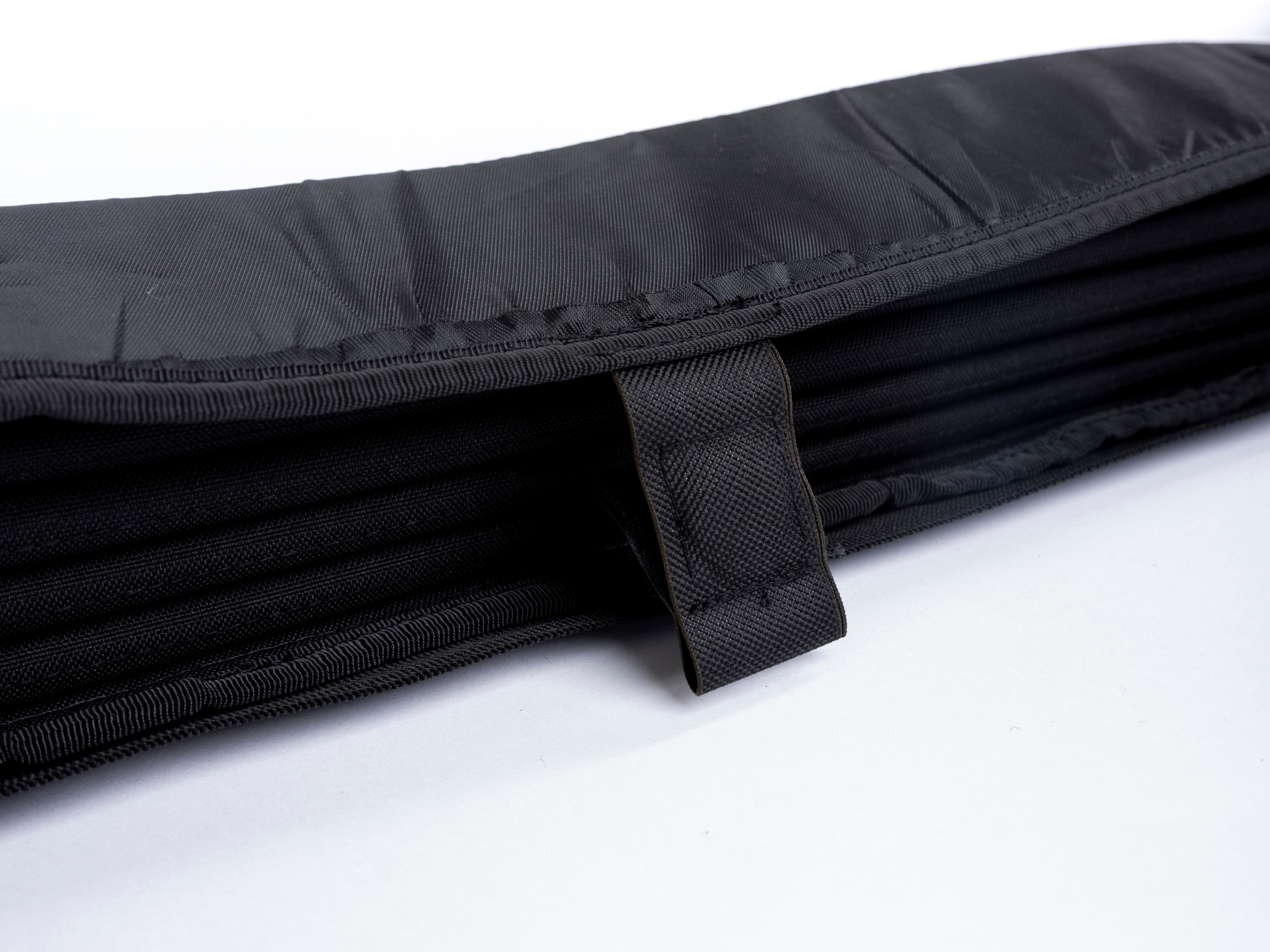 Black privacy curtain fold with interior mesh-like fabric strap