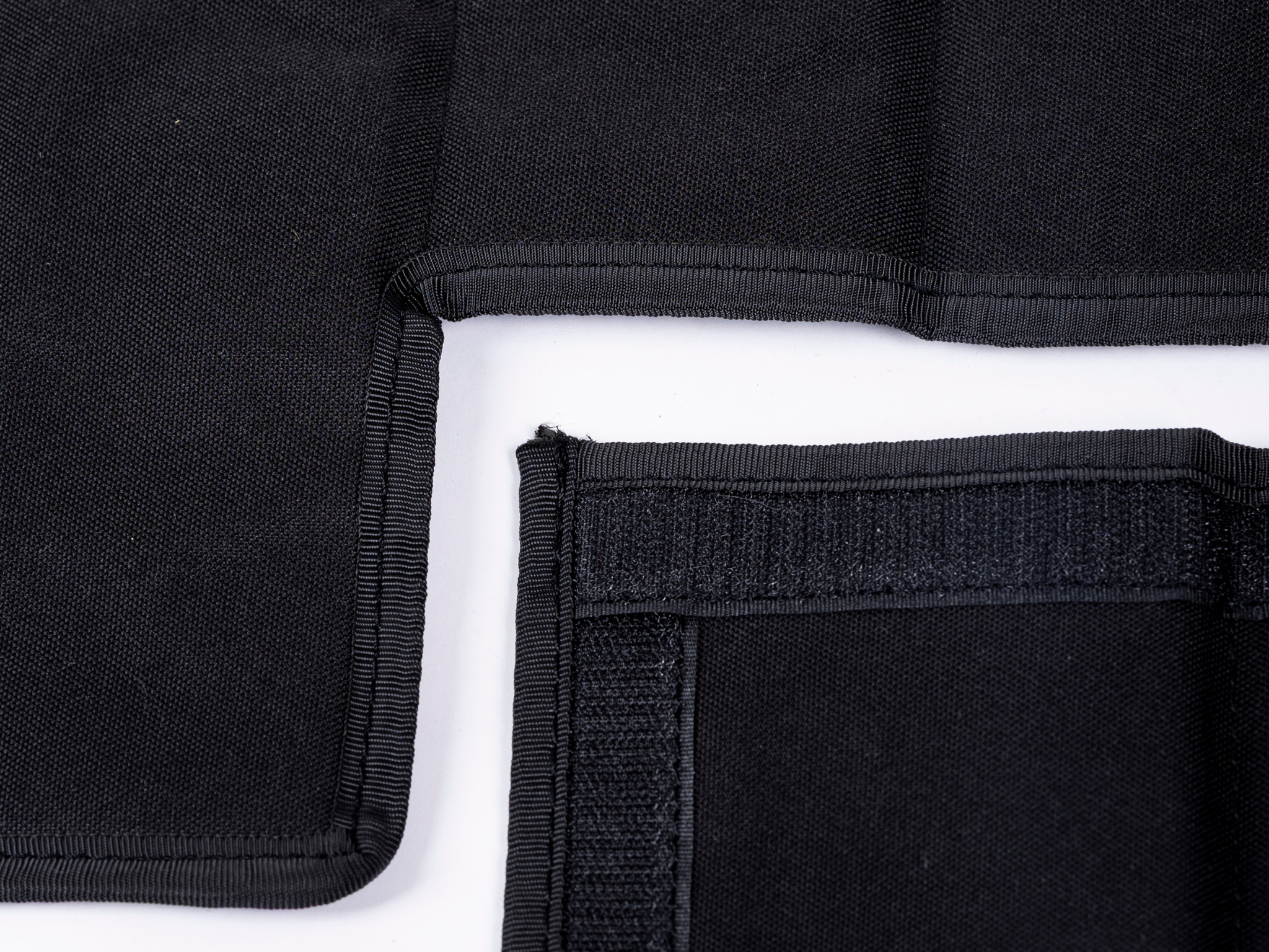 Black privacy curtain hem with reinforced corner and stitched pocket panel