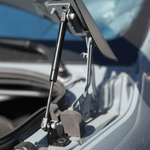 Hood strut assembly with pivot bracket holding the hood above engine bay