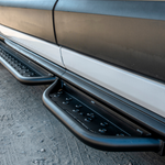 Installed black perforated side steps with anti-slip holes along the van