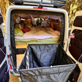 Opened shower kit bag with black liner and hanging compartments inside a van