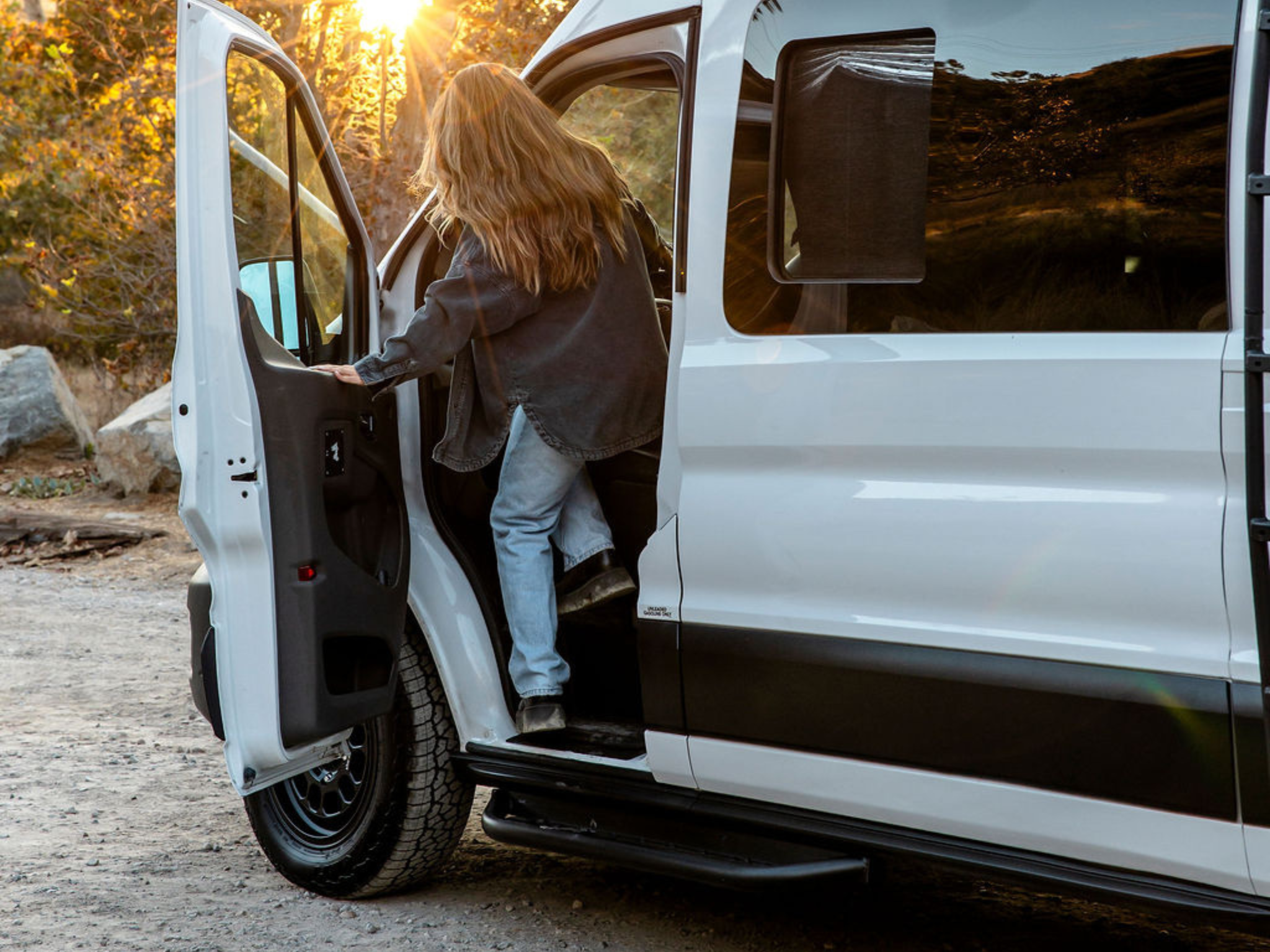 Black side step installed on Ford Transit door area with perforated tread