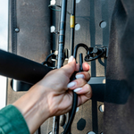 Hand attaching a tool bracket to the perforated rear-door storage rack panel