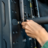 Hand securing accessories to a perforated rear-door rack panel with metal mounting posts
