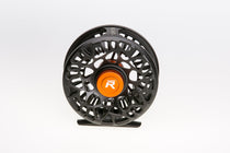 Black fishing reel with orange center cap and perforated spool wheel.