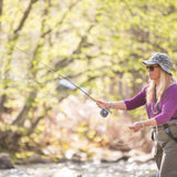 Angler casting with fly rod on river in woods